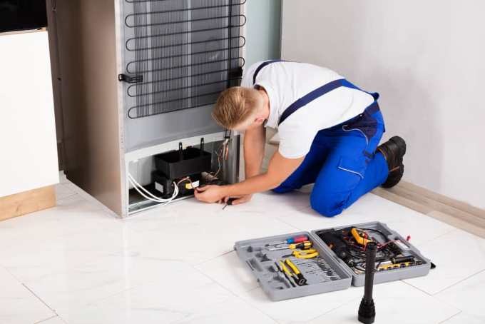 Técnico reparando refrigeradora a domicilio en Lima